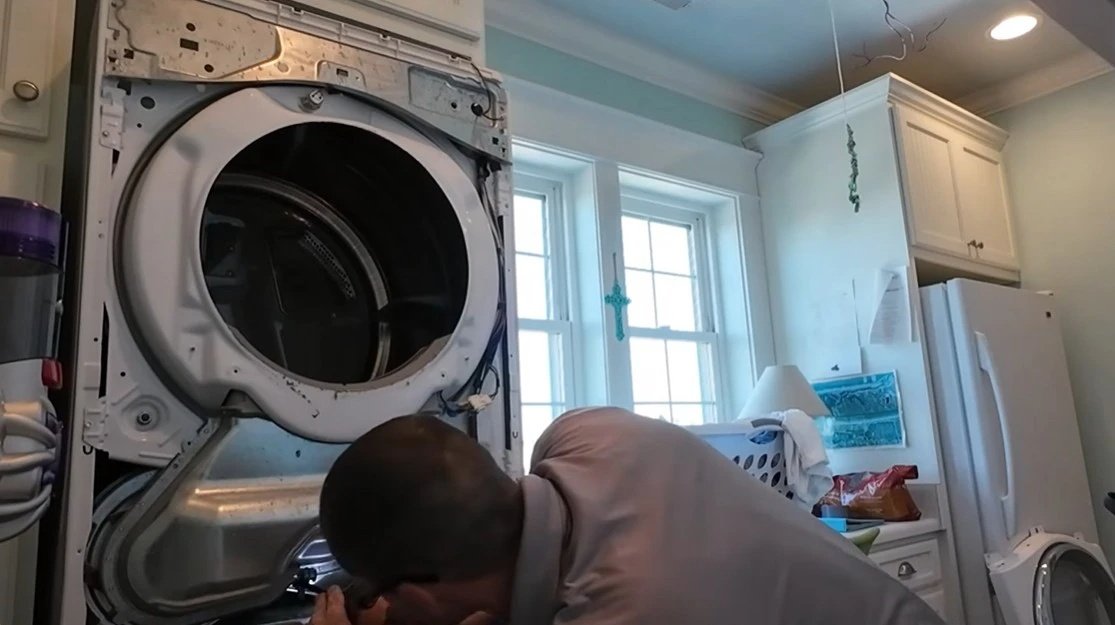 Technician repairing the open drum of a front-load washing machine